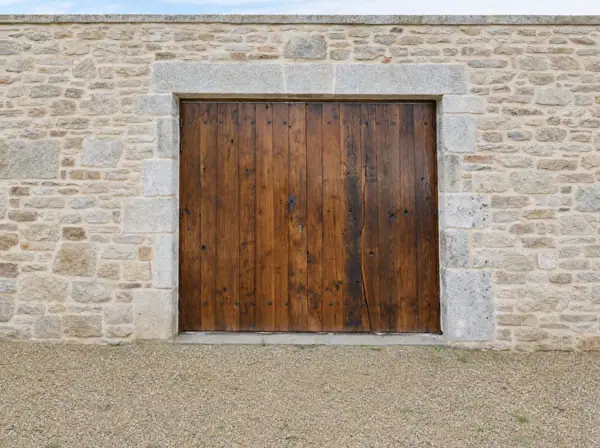 Portail en vieux chêne à clous en losange, encadrement de granit