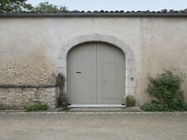 Portail gris-vert cintré avec petite porte