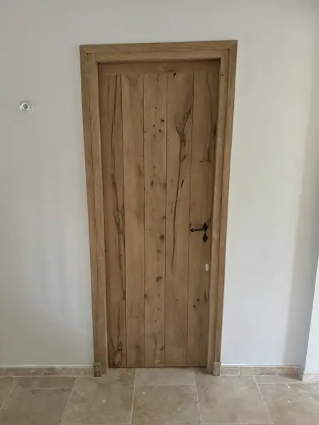 Porte en chêne rustique dans un mur blanc